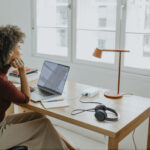 successful young afro woman sitting at her desk in her home office